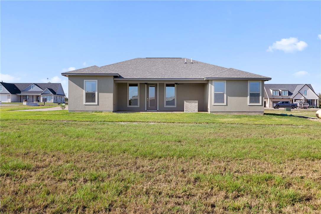 6512 Agave Court Bryan, TX 77808 - Photo 12 of 42 Rear view of property with a lawn, stucco siding, roof with shingles, and a patio area