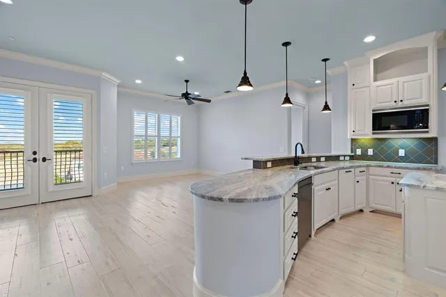 a large kitchen with granite countertop a large center island attached withe living room