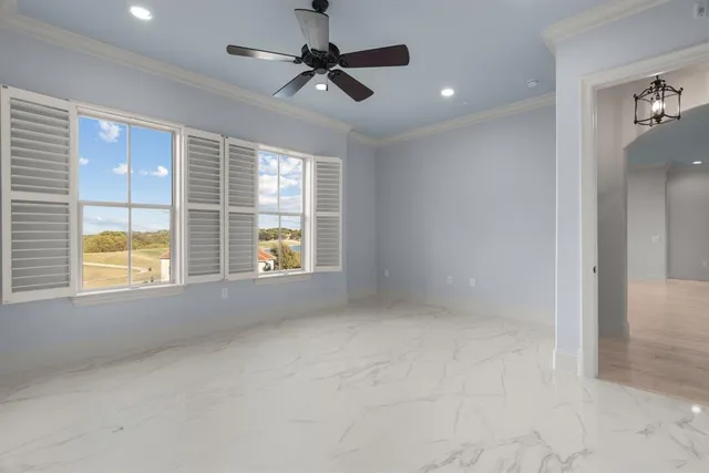 en empty room with windows and ceiling fan