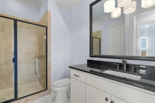 a bathroom with a granite countertop sink toilet and shower