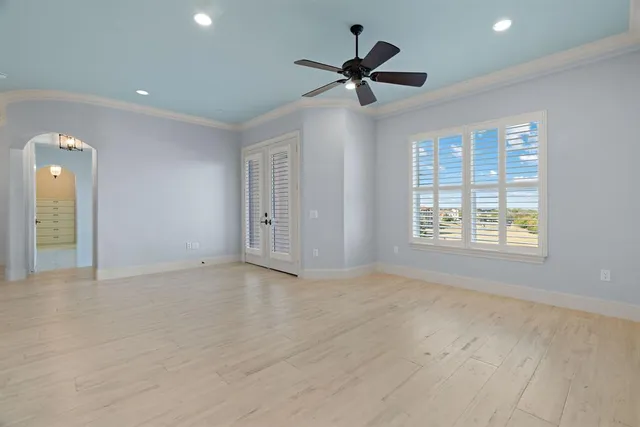 a view of a livingroom with a ceiling fan & windows