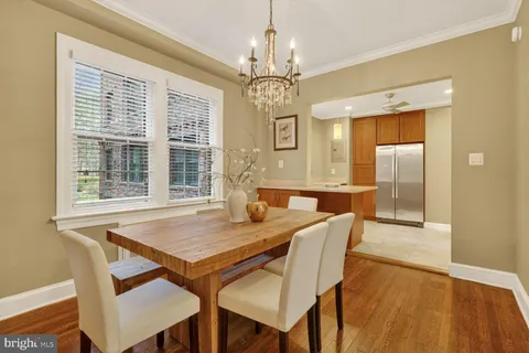 a dining hall with stainless steel appliances granite countertop a dining table and chairs with wooden floor