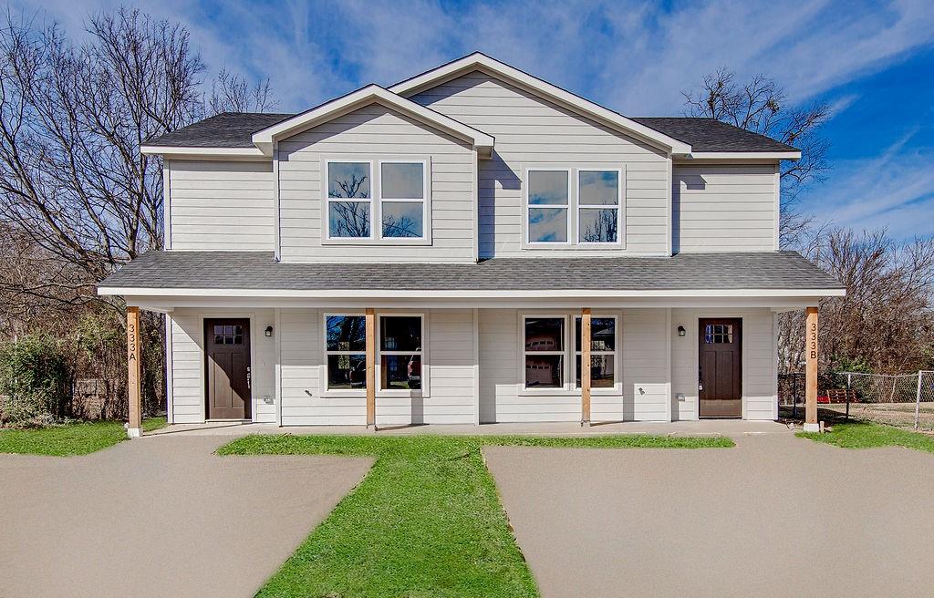 a view of a white house with large windows and a table and chairs