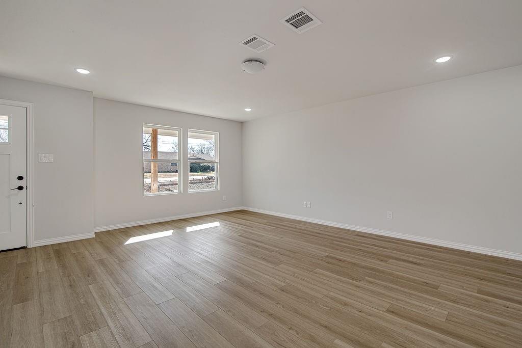333 North Field Street Burleson, TX 76028 - Photo 2 of 35 an empty room with wooden floor and windows