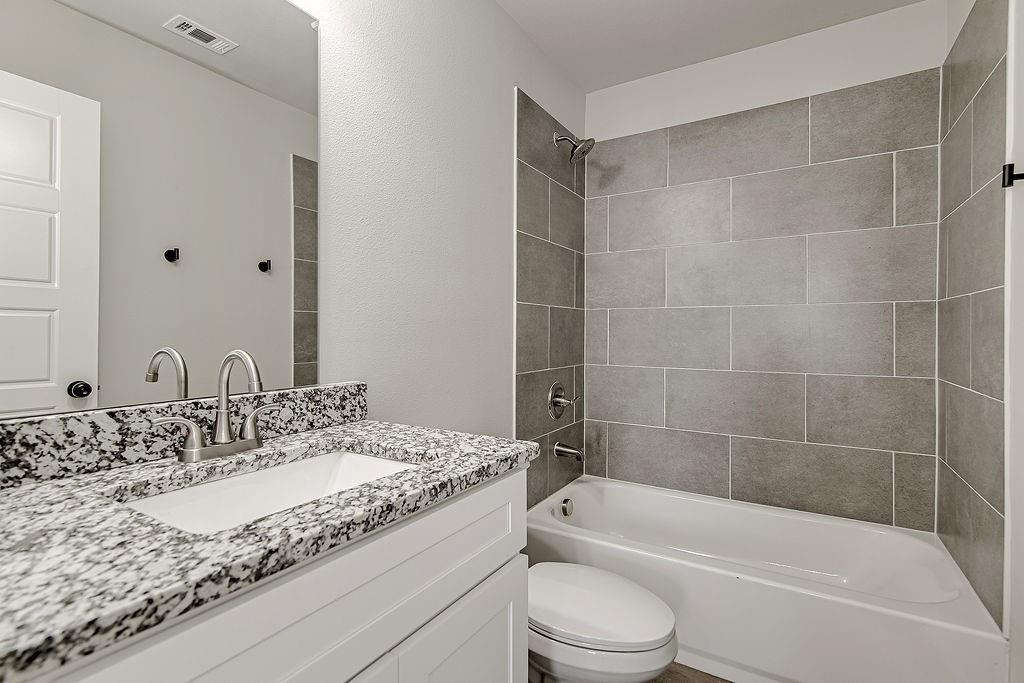 333 North Field Street Burleson, TX 76028 - Photo 22 of 35 a bathroom with a granite countertop sink a toilet and bathtub