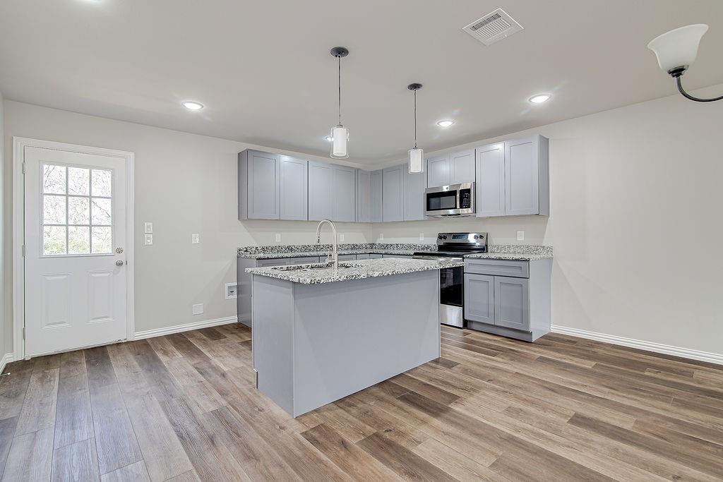 333 North Field Street Burleson, TX 76028 - Photo 28 of 35 a kitchen with granite countertop white cabinets and stainless steel appliances