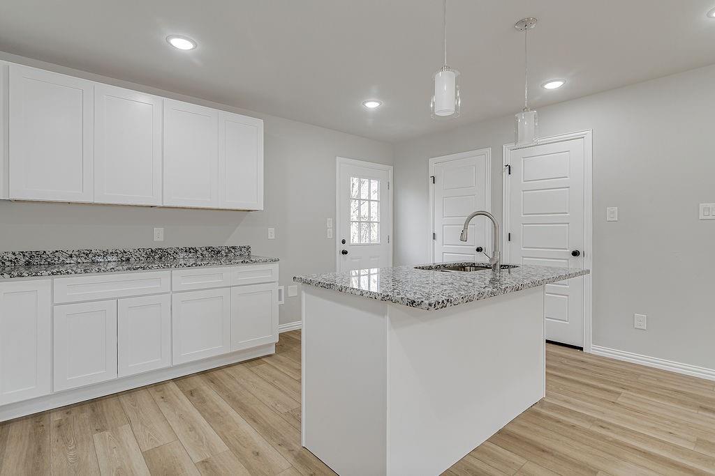 333 North Field Street Burleson, TX 76028 - Photo 7 of 35 a kitchen with granite countertop white cabinets and a sink