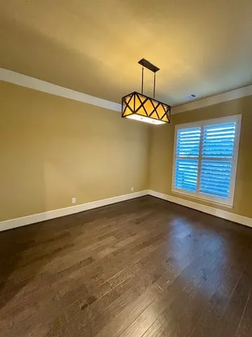 a view of a room with a window and hardwood
