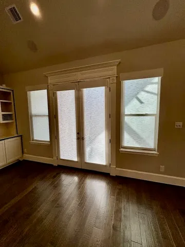 a view of wooden floor and windows in a room