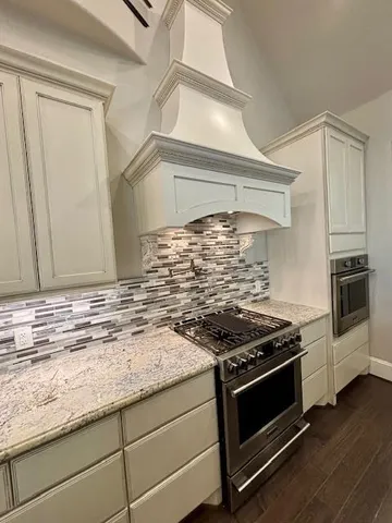 a kitchen with granite countertop stainless steel appliances a stove and a sink