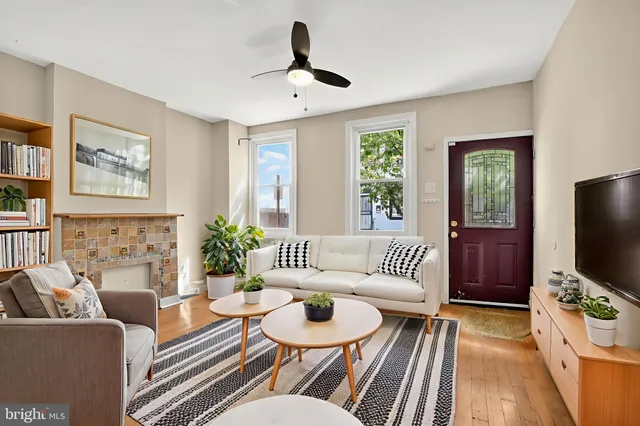 a living room with furniture a flat screen tv and a window