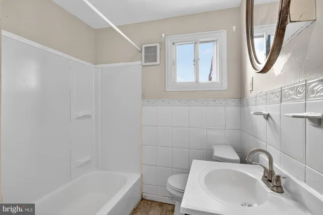 a bathroom with a sink a toilet and a mirror