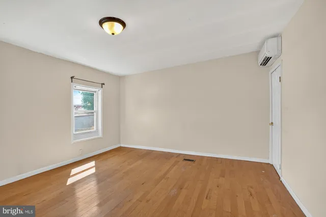 wooden floor in an empty room with a window