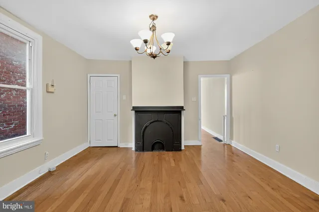 a view of a livingroom with a fireplace wooden floor and windows