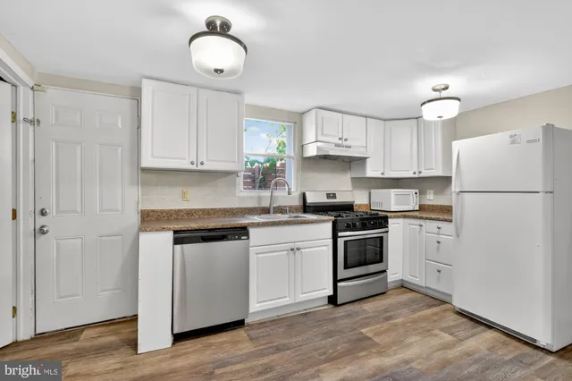 a kitchen with white cabinets and stainless steel appliances