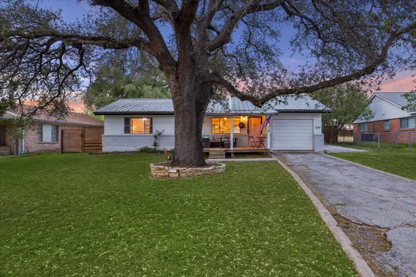 a front view of house with a garden