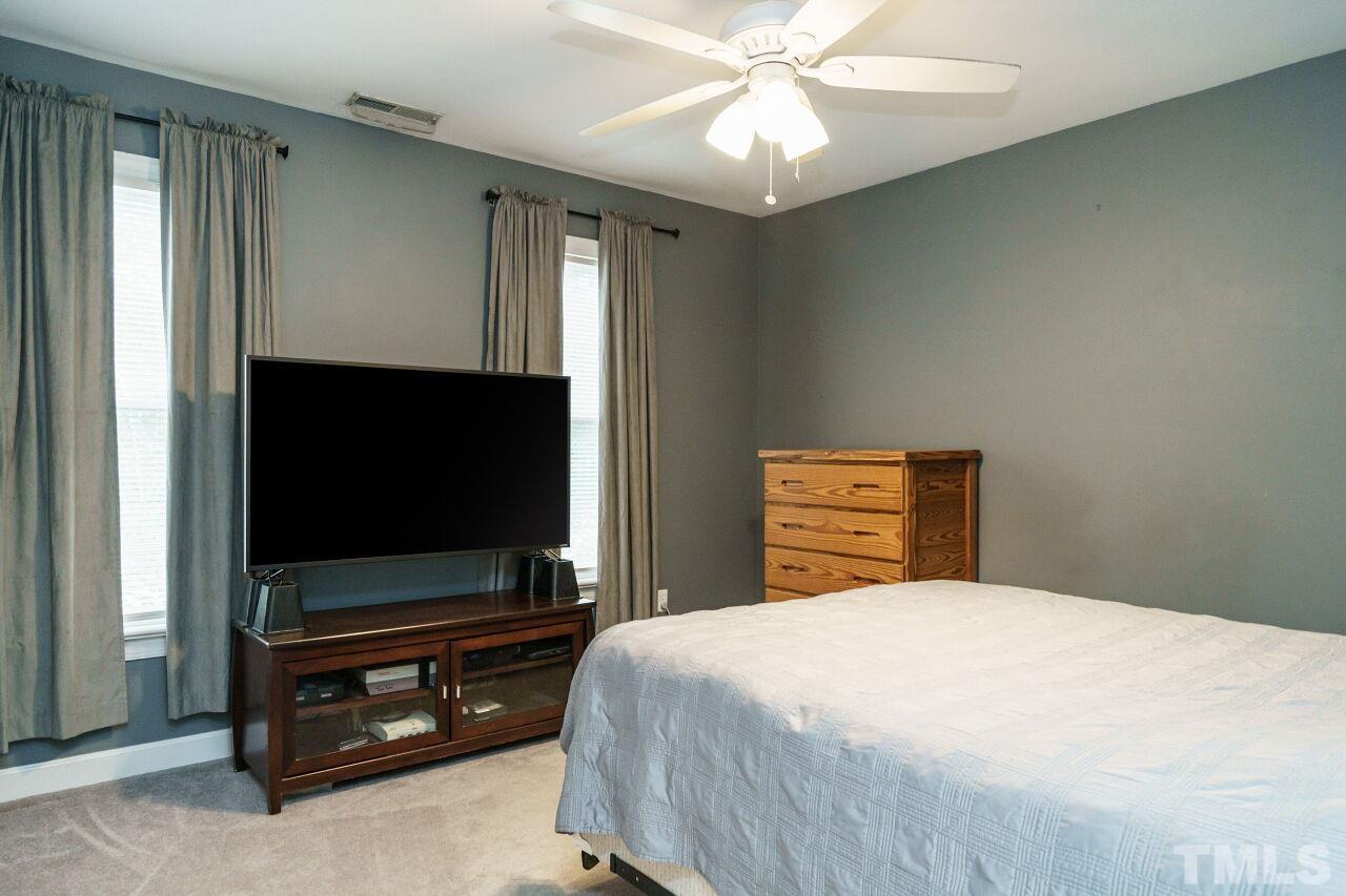 7800 Laurel Mountain Road Raleigh, NC 27613 - Photo 19 of 31 a bedroom with a bed and a flat screen tv