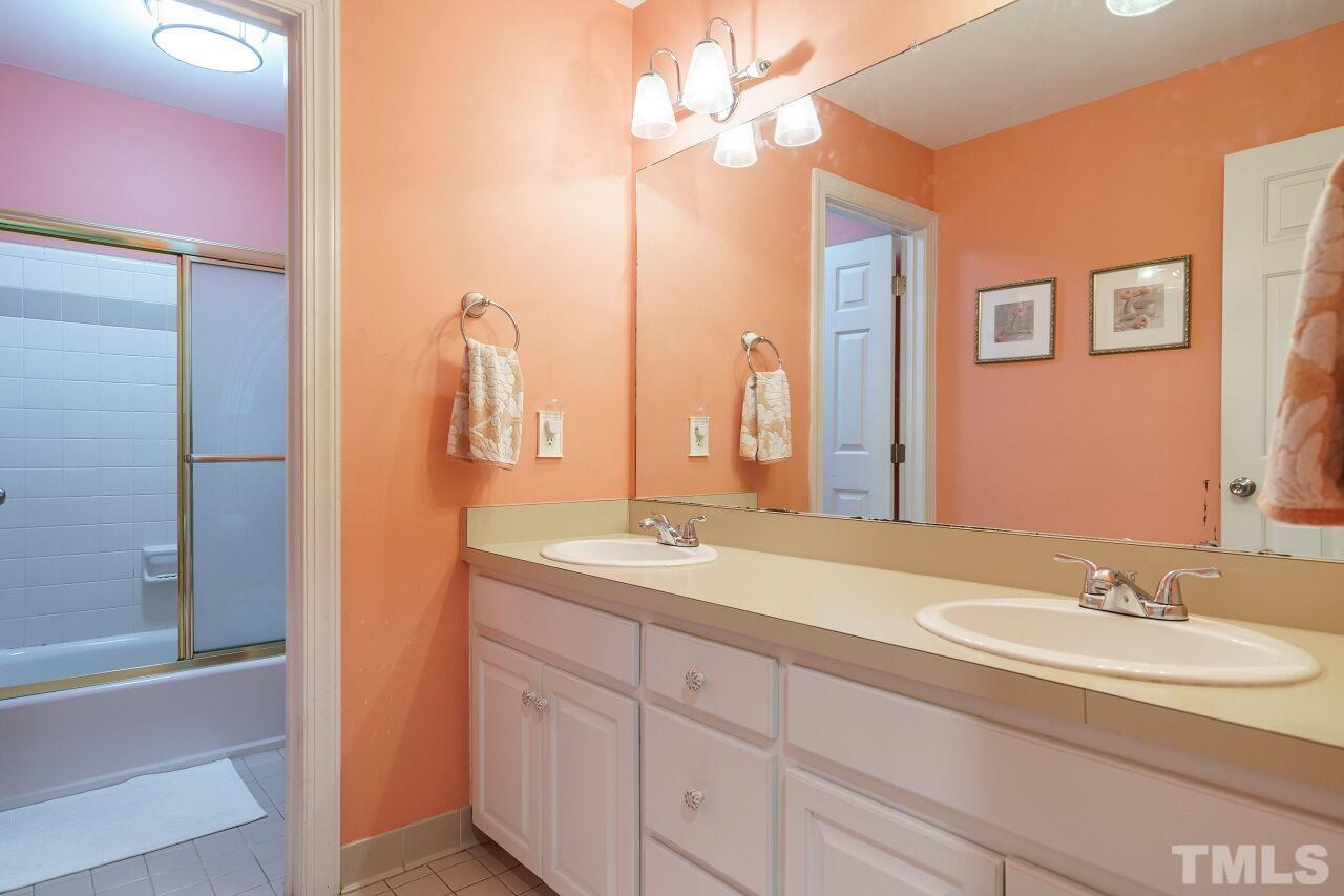 7800 Laurel Mountain Road Raleigh, NC 27613 - Photo 21 of 31 a bathroom with a double vanity sink a mirror and a shower