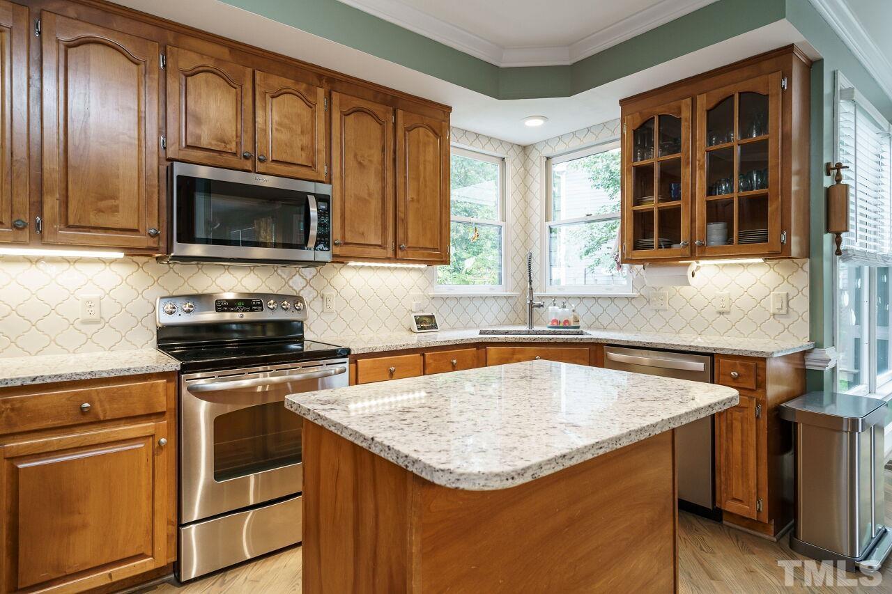 7800 Laurel Mountain Road Raleigh, NC 27613 - Photo 7 of 31 a kitchen with granite countertop stainless steel appliances stove microwave and cabinets