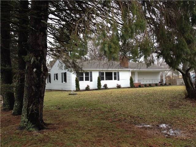 a front view of a house with yard and tree