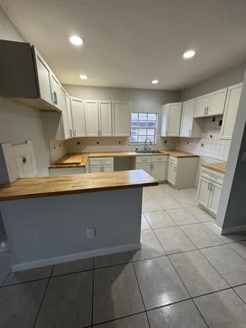 a kitchen with a sink a counter top space cabinets and stainless steel appliances