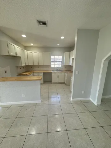 a kitchen with a cabinets a counter top space stainless steel appliances and a window