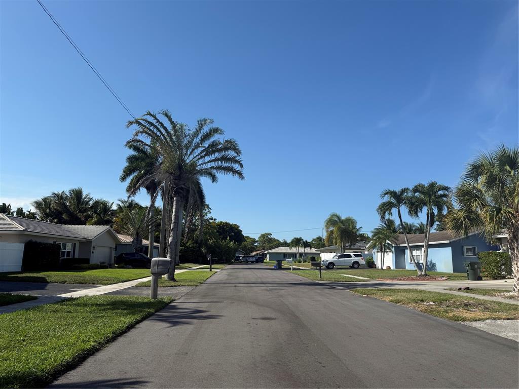 105 Orchard Ridge Lane Boca Raton, FL 33431 - Photo 23 of 24 a front view of a house with a yard and palm trees