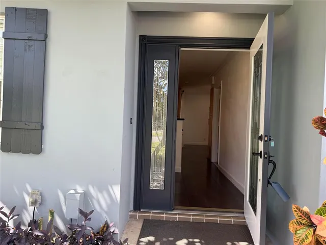 a view of a hallway with wooden floor and a door