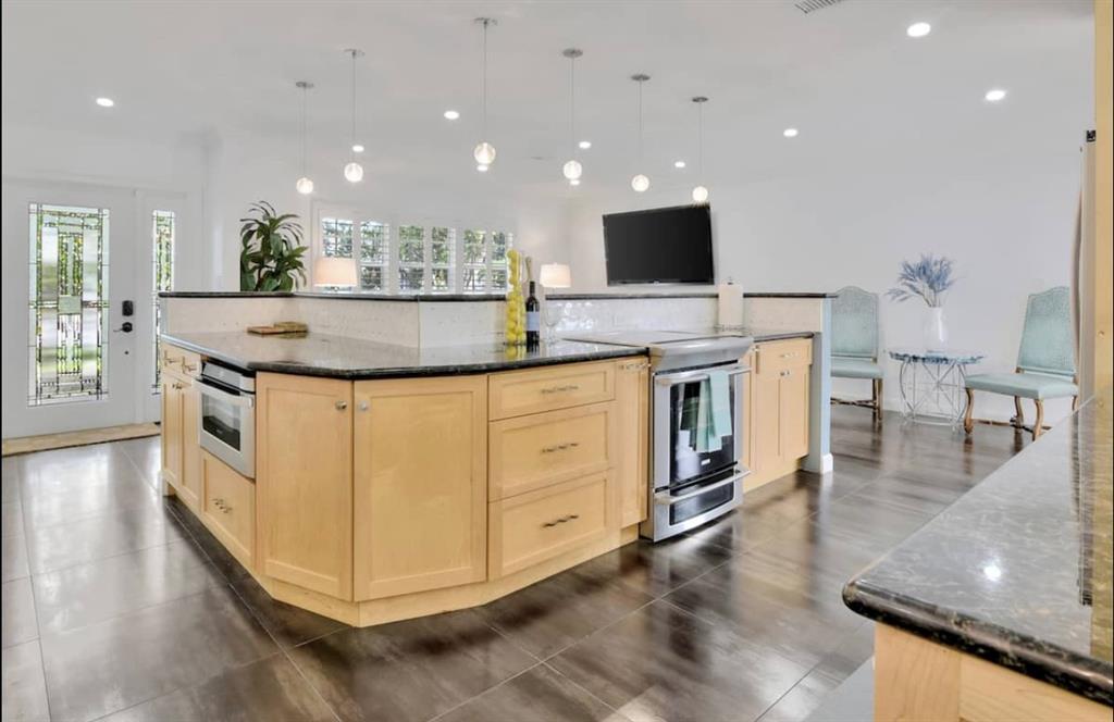 105 Orchard Ridge Lane Boca Raton, FL 33431 - Photo 7 of 24 a kitchen with stainless steel appliances granite countertop a stove and a view of living room