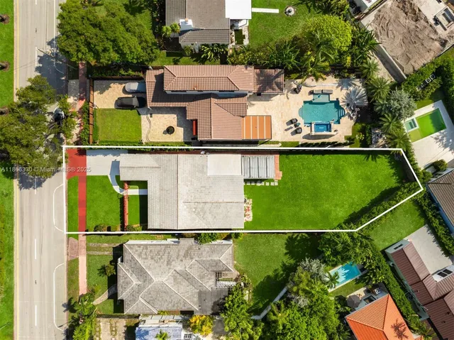 an aerial view of a house with a garden and lake view