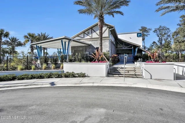 a view of a patio with table and chairs potted plants and floor to ceiling window