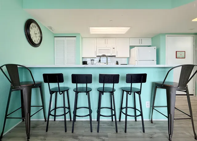 a kitchen with a table chairs and a view of living room