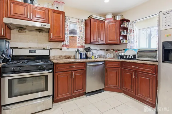 a kitchen with stainless steel appliances granite countertop a stove sink and cabinets