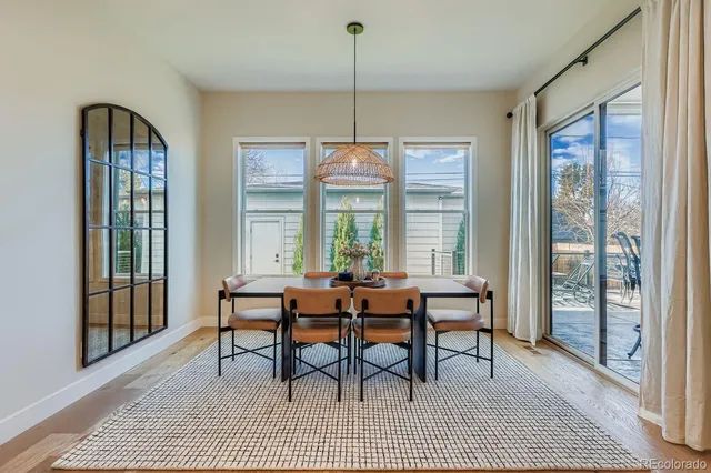 a dining room with furniture a chandelier and wooden floor