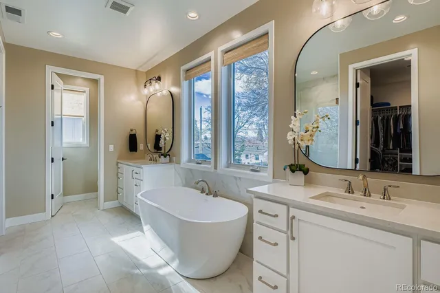 a bathroom with a tub sink and mirror