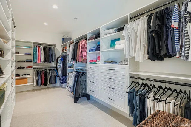 a view of walk in closet with clothes and shoes