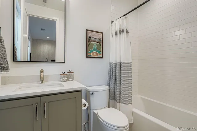 a bathroom with a toilet a sink a bath tub and mirror