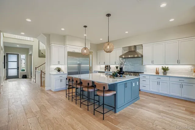 a kitchen with stainless steel appliances granite countertop a stove a sink dishwasher and a wooden cabinets with wooden floor