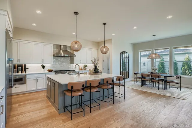a large kitchen with lots of furniture a sink appliances and a dining table