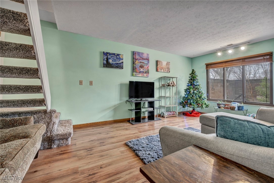 9956 Johnnycake Ridge Road, Unit B5 Painesville, OH 44077 - Photo 16 of 24 Living room with wood-type flooring, a textured ceiling, and track lighting