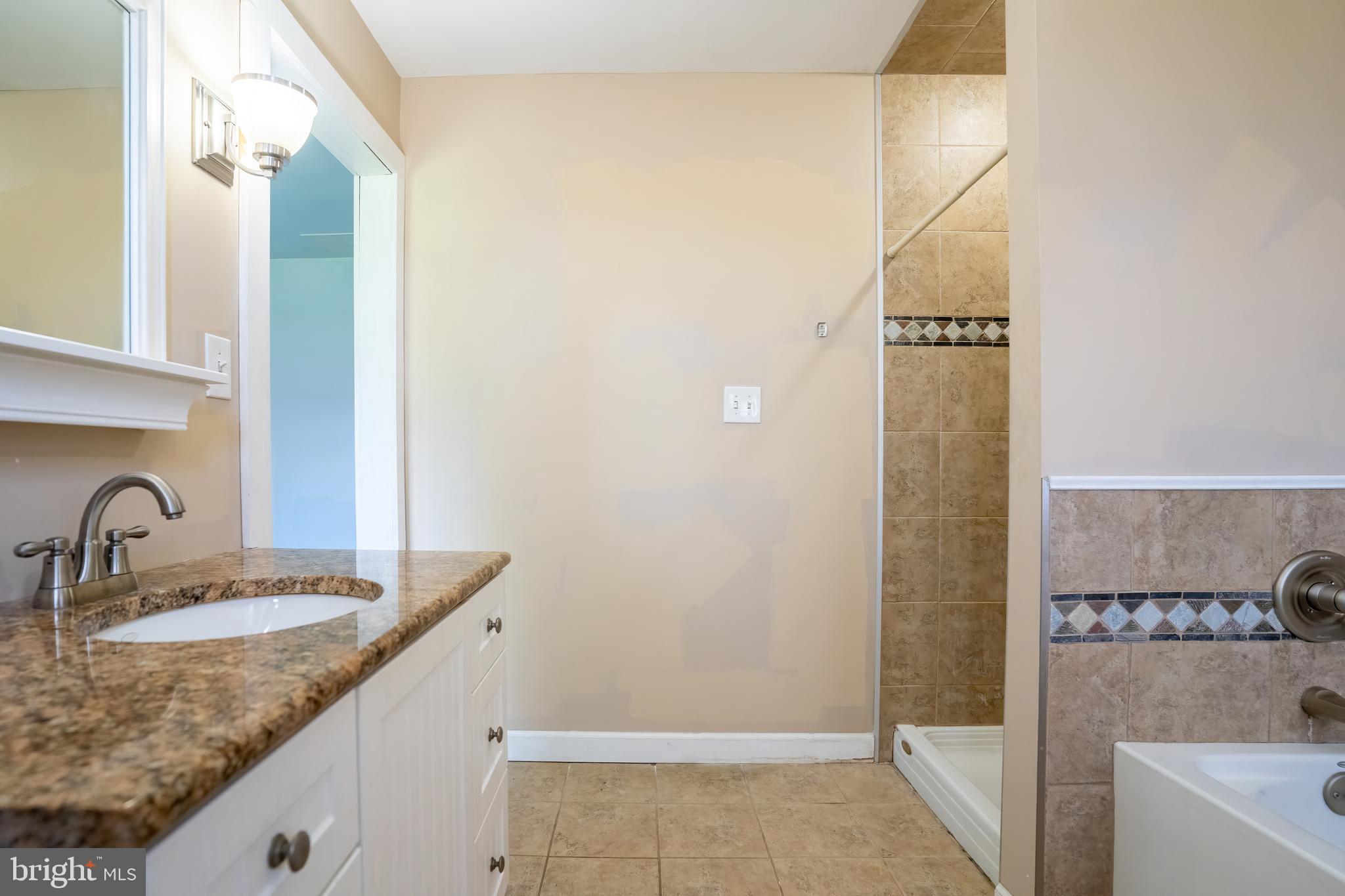 74 Woods Road Hightstown, NJ 08520 - Photo 29 of 57 a bathroom with a granite countertop sink and a mirror
