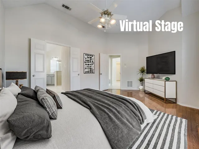 a bedroom with a bed and a flat tv screen on wall