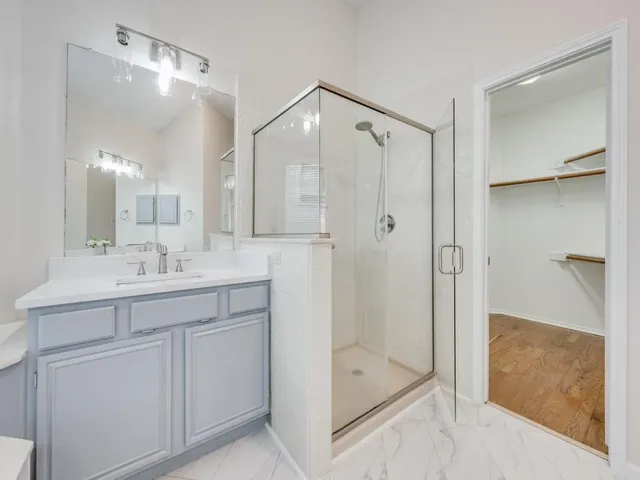 a bathroom with a shower sink and mirror