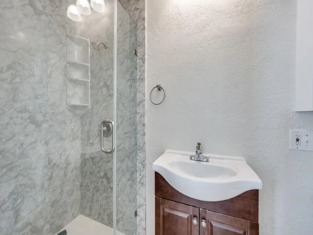 a bathroom with a sink a toilet and shower