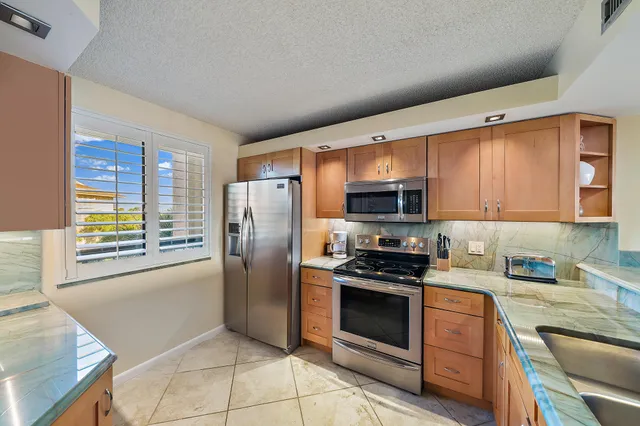 a kitchen with stainless steel appliances a sink a stove and a refrigerator