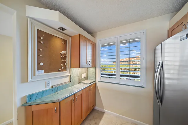 a kitchen with stainless steel appliances kitchen island granite countertop a refrigerator and cabinets