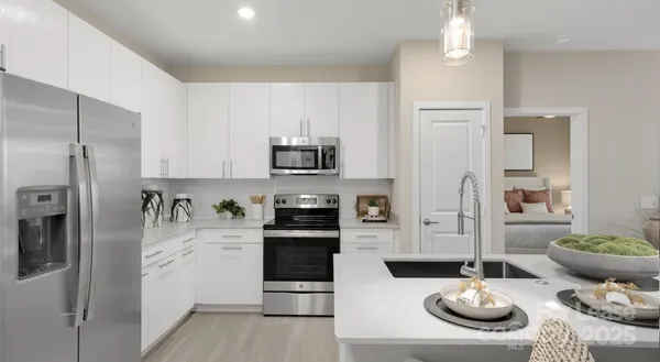 a kitchen with stainless steel appliances kitchen island granite countertop a refrigerator and a stove top oven
