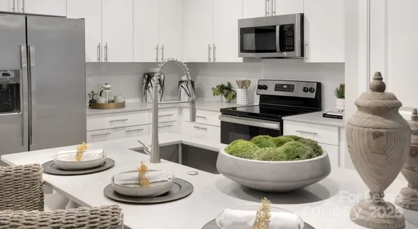 a kitchen with a table and a potted plant