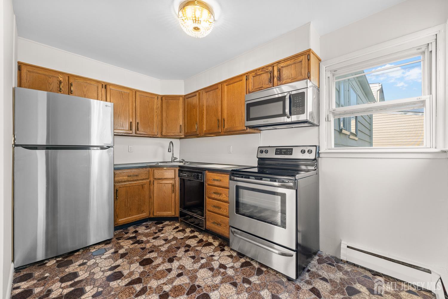 82 Mercer Street Menlo Park Terrace, NJ 08840 - Photo 11 of 31 a kitchen with stainless steel appliances granite countertop a refrigerator sink and stove