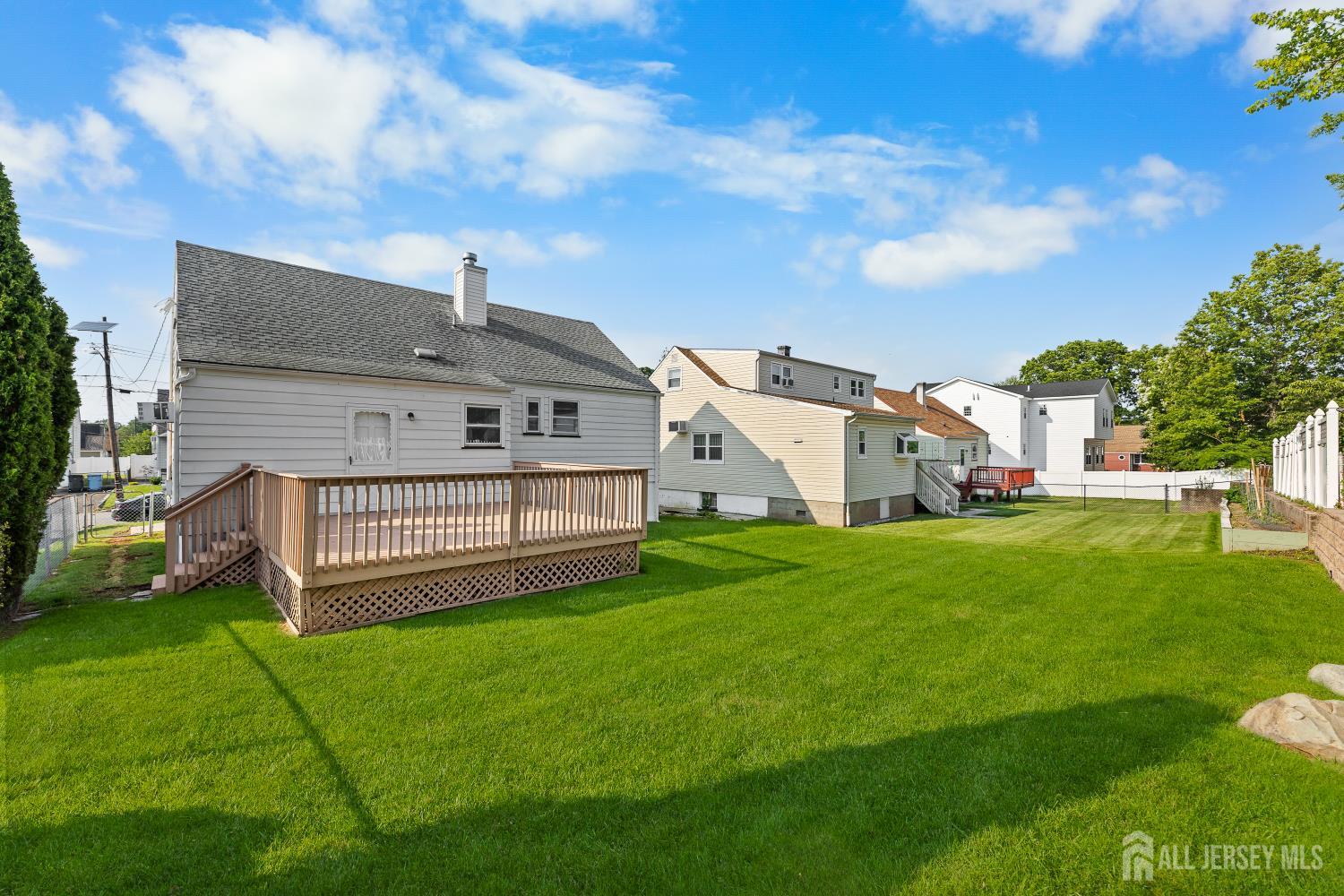 82 Mercer Street Menlo Park Terrace, NJ 08840 - Photo 18 of 31 a view of a white house in front of a big yard plants and large trees